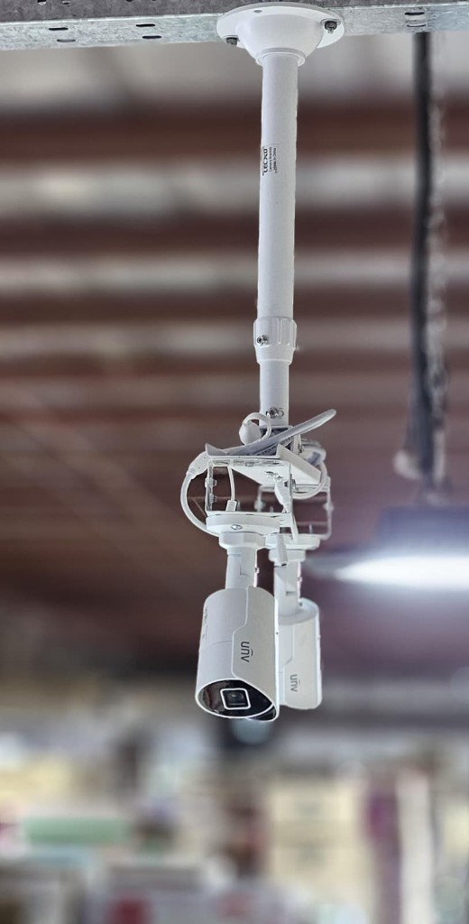 Twin Uniview bullet CCTV cameras pole-mounted on high warehouse ceiling in Kuwait